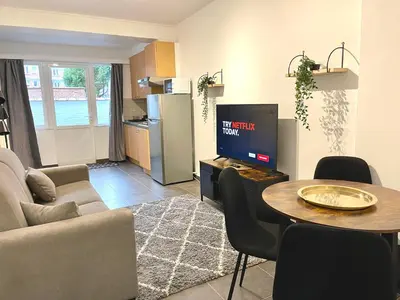 a living room with a couch and a table with a tv at Duden Park Brussels - Cosy APT 1 Bedroom in Brussels