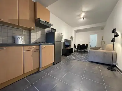 a kitchen with a counter and a living room at Duden Park Brussels - Cosy APT 1 Bedroom in Brussels
