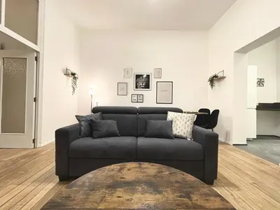 a living room with a couch and a table at Charming Uccle - 1 Bedroom APT Brussels in Brussels