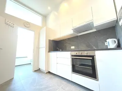 a kitchen with white cabinets and a stove at Charming Uccle - 1 Bedroom APT Brussels in Brussels