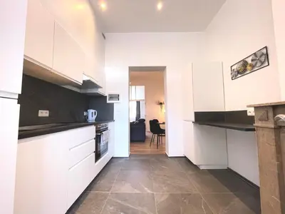 a kitchen with white cabinets and a tile floor at Charming Uccle - 1 Bedroom APT Brussels in Brussels