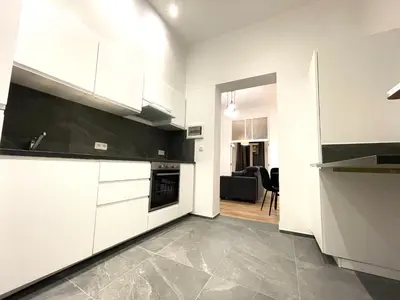 a kitchen with white cabinets and a living room at Charming Uccle - 1 Bedroom APT Brussels in Brussels
