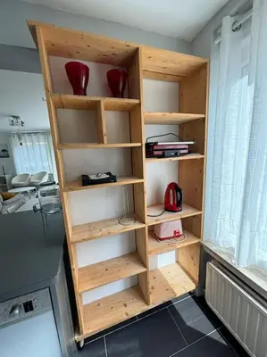 a wooden book shelf with red vases on it at Résidence 