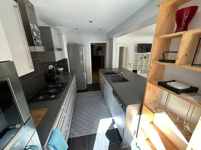 a kitchen with gray counters and a stove top oven at Résidence 