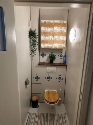 a small bathroom with a toilet with a wooden seat at Résidence 