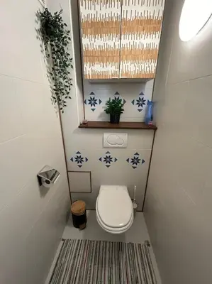 a small bathroom with a toilet and a window at Résidence 