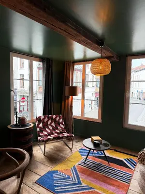 a living room with a chair and a table at Cosy Boudoir Suites - 4p in Antwerp