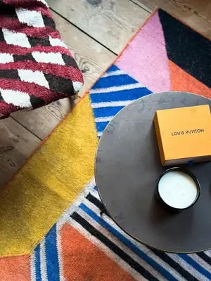 a table on a rug with a book and a candle at Cosy Boudoir Suites - 4p in Antwerp