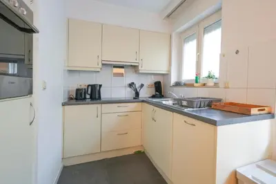a kitchen with white cabinets and a sink at Cocon tout chaud - Pour couple avec ou sans bébé au rez-de-chaussée in Brussels