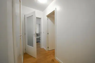 an empty hallway with two doors and a mirror at Cocon tout chaud - Pour couple avec ou sans bébé au rez-de-chaussée in Brussels