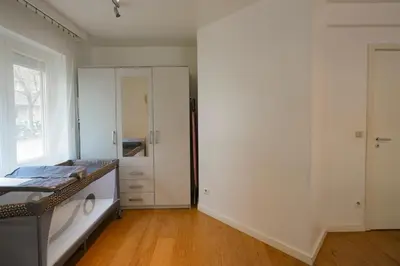a white room with a closet and a mirror at Cocon tout chaud - Pour couple avec ou sans bébé au rez-de-chaussée in Brussels
