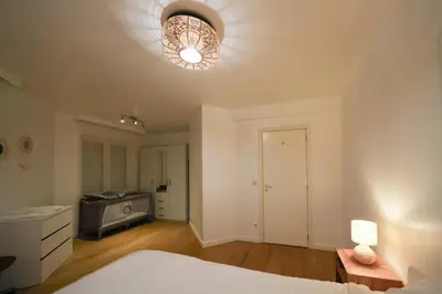 a bedroom with a bed and a light on the ceiling at Cocon tout chaud - Pour couple avec ou sans bébé au rez-de-chaussée in Brussels