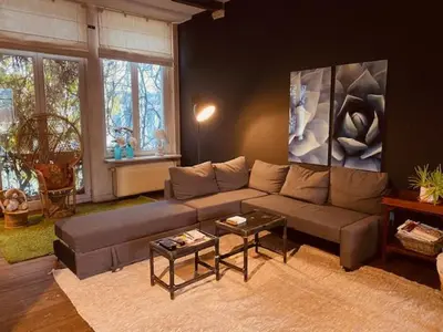 a living room with a couch and a table at Spacious duplex with terrace in the middle of the center in Ghent