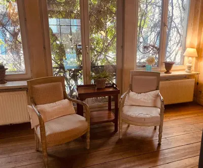 two chairs and a table in a room with windows at Spacious duplex with terrace in the middle of the center in Ghent