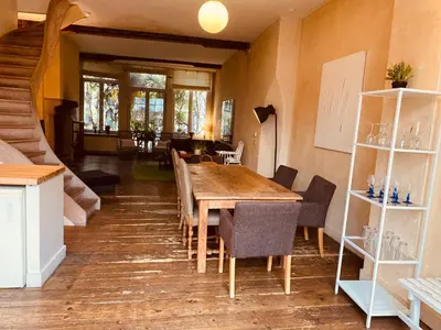 a dining room with a wooden table and chairs at Spacious duplex with terrace in the middle of the center in Ghent