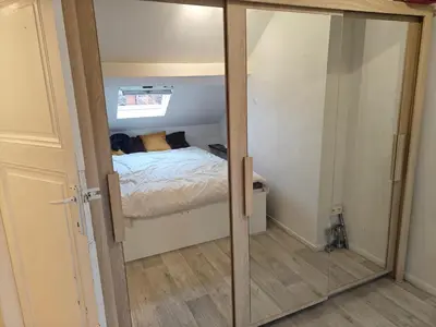 a small room with a bed and a mirror at Acacia Etterbeek in Brussels