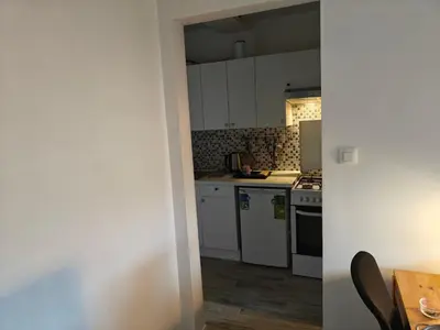 a small kitchen with white cabinets and a table at Acacia Etterbeek in Brussels