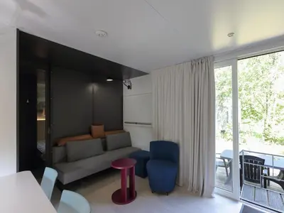 a living room with a couch and a table at Chalet in Baalse Hei with Modern Comforts in Turnhout