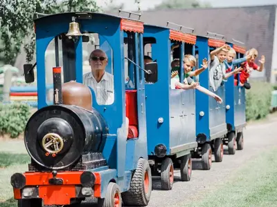 a group of children riding on a small train at Charming Breebos Getaway in Rijkevorsel