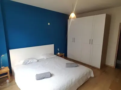 a bedroom with a white bed and a blue wall at Fully equipped two bedroom apartment Schuman area in Brussels