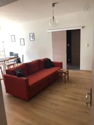 a living room with a red couch and a table at Fully equipped two bedroom apartment Schuman area in Brussels