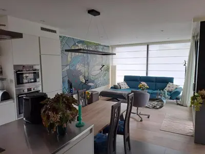 a living room with a table and a blue couch at Carlotta Penthouse in Ghent