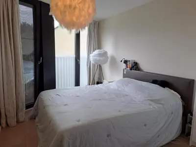 a bedroom with a bed and a lamp in it at Carlotta Penthouse in Ghent