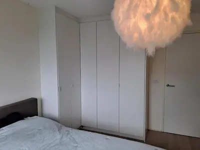 a bedroom with a bed and a large pom pom chandelier at Carlotta Penthouse in Ghent