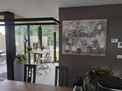 a dining room with a table and a painting on the wall at Carlotta Penthouse in Ghent