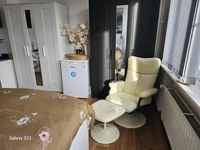 a room with a bed and a chair in it at Friend House in Brussels