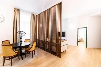 a dining room with a table and chairs and a television at Gotha Aparthotel in Brussels