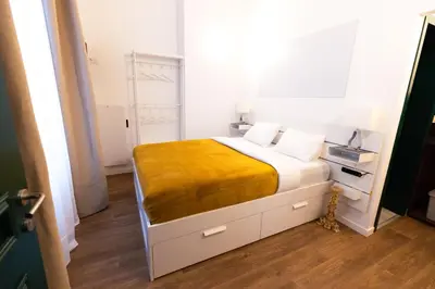 a bedroom with a bed with a yellow blanket on it at Gotha Aparthotel in Brussels