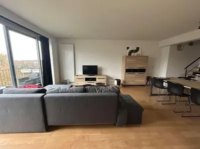 a living room with a couch and a piano at Duplex appartement, Burcht in Zwijndrecht