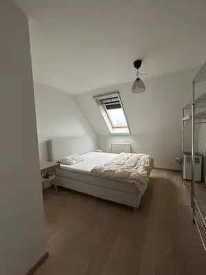 a white bedroom with a bed and a window at Duplex appartement, Burcht in Zwijndrecht