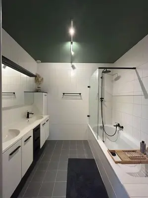 a white bathroom with a shower and a sink at Duplex appartement, Burcht in Zwijndrecht