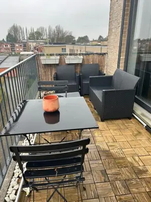 a table and chairs on a balcony with an orange bowl on it at Duplex appartement, Burcht in Zwijndrecht