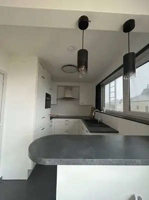 a kitchen with white cabinets and a counter top at Duplex appartement, Burcht in Zwijndrecht