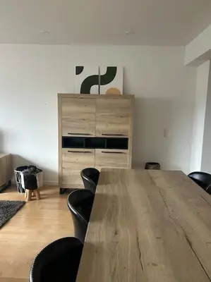 a room with a wooden table with chairs and a dresser at Duplex appartement, Burcht in Zwijndrecht