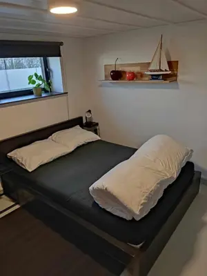 a bed with two pillows on it in a room at Maison Toulouse in Affligem