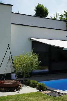 a building with awning next to a swimming pool at Maison Toulouse in Affligem