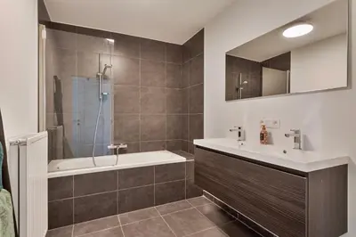 a bathroom with a tub and a sink and a shower at Ruim 3 slaapkamer appartement met parking nabij NATO in Machelen