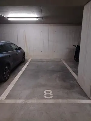 a parking garage with a car parked in it at Ruim 3 slaapkamer appartement met parking nabij NATO in Machelen