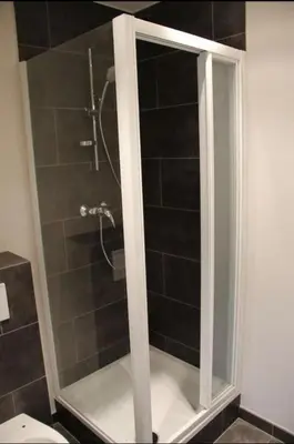 a shower with a glass door in a bathroom at Voskenslaan in Ghent