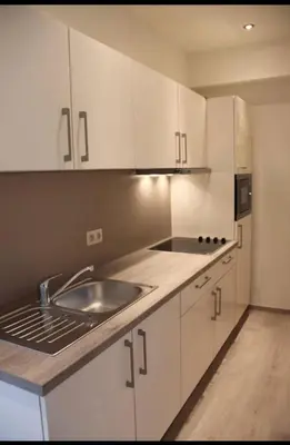 a kitchen with white cabinets and a sink at Voskenslaan in Ghent