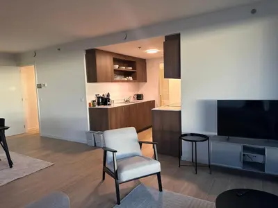 a living room with a chair and a television at Beautiful Apartment with Panoramic View of center with roof terrace in Brussels