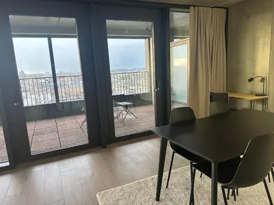 a dining room with a table and chairs and a balcony at Beautiful Apartment with Panoramic View of center with roof terrace in Brussels