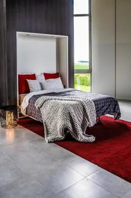 a bedroom with a bed and a red rug at Watertoren - Chateau d'Eau in Steenokkerzeel