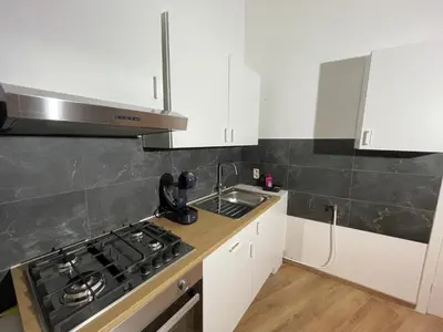 a kitchen with white cabinets and a stove and a sink at Heart of Antwerpen in Antwerp