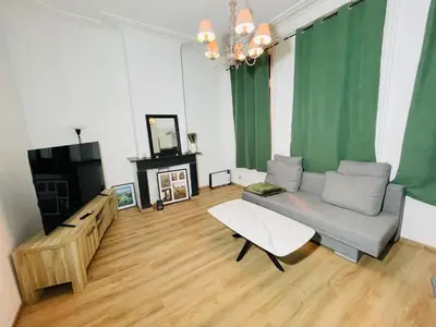 a living room with a couch and a tv at Heart of Antwerpen in Antwerp