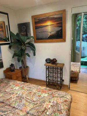 a bedroom with a bed and a table with a plant at Tropical Room in Brussels